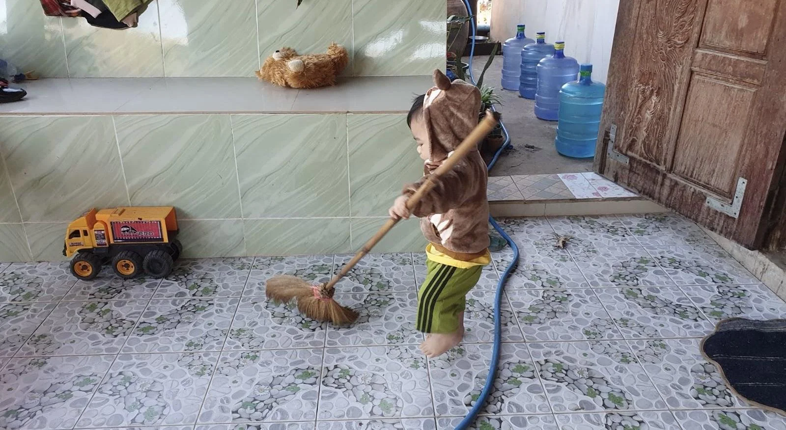 เด็กผู้ชายกำลังกวาดบ้าน